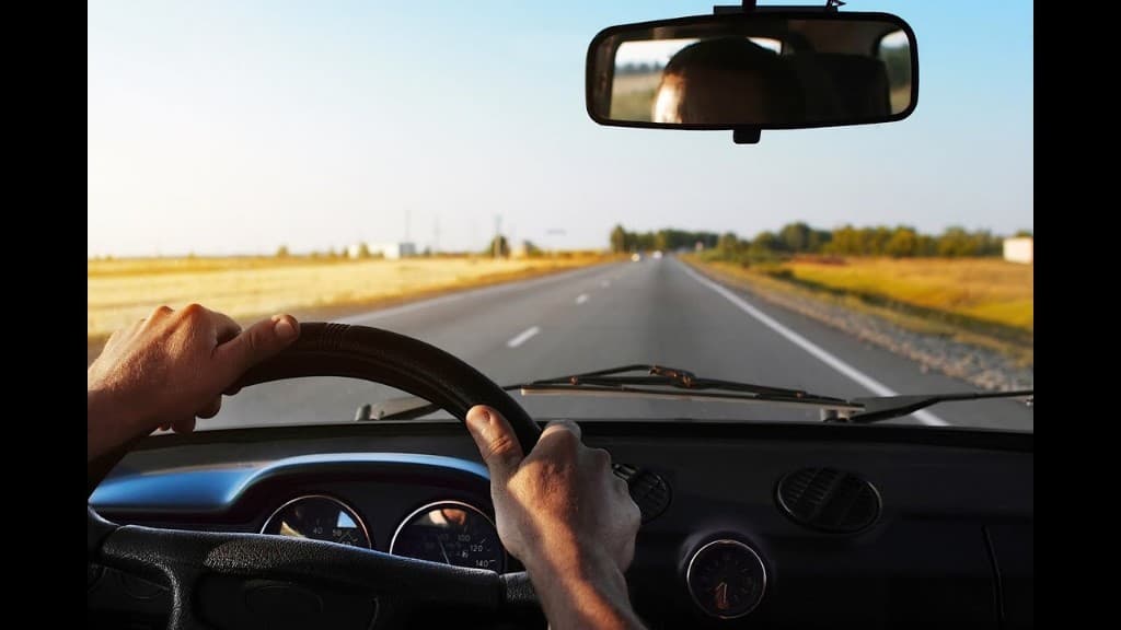 View from the driver's seat on a two-lane highway in daylight